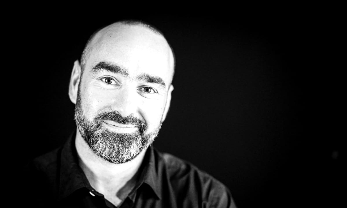 Portrait studio noir et blanc d'Alexandre De Sousa sur fond sombre